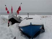 Boote im Schnee: Am Strandzugang von Stubbenfelde liegen die Fischerboote im Schnee.