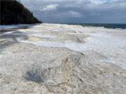 Wie alter Stein liegen merkwrdig geformte Eismassen am Strand des Kaiserbades Bansin.