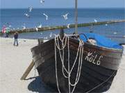 Zutaten eines Ostseeurlaubs: Ostseestrand, Fischerboot, blaues Wasser, Mwen.