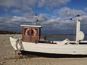 Wolkenkulisse: Fischerboot auf dem Strand des Ostseebades Koserow.