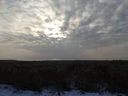 Winterhimmel über Usedom: Wolken über dem gefrorenen Achterwasser.