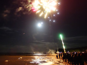 Publikum: Viele Menschen bewundern das Feuerwerk am Ostseestrand.