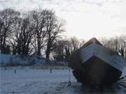 Winterimpressionen von Usedom: Fischerboot auf dem verschneiten Ostseestrand.