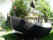 Am Kirchplatz von Garz liegt ein altes Fischerboot als maritime Dekoration.