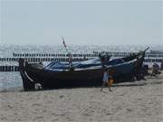 Gleiendes Sonnenlicht auf dem Loddiner Ostseestrand: Fischerboot am Klpinseer Strand.