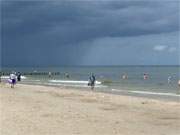 Regen ber der Ostsee: Der Sonnenschein ragt unter die dunkeln Wolken.