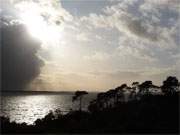 Dramatische Regenwolken ber dem Achterwasser: Wunderbar treten die Silhouetten der Bume hervor.