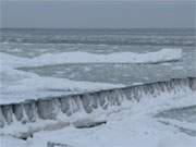 Trge schwappt das gefrierende Ostseewasser zwischen den Buhnen.