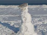 Mit Mütze: Am Strand des Ostseebades Karlshagen begrüßt ein Schneemann die Urlaubsgäste.