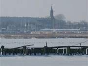 Die alte Holzpier im Hafen Peenemnde; im Hintergrund Marina und Kirche Krslin.