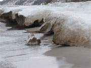 Strandsand dringt in die Eisberge ein und lsst sie wie Sandstein aussehen.