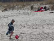 Fußbad: Junge mit Ball am Ostseestrand des Bernsteinbades Ückeritz.