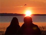 Besinnlicher Moment: Ein Paar beobachtet den Sonnenuntergang ber dem Achterwasser.