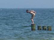 Kopfsprung: Ein Badegast hat sich am Ostseestrand von Klpinsee auf eine Buhne vorgewagt.