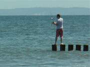 Gewagter Standort: Angler auf einer Buhne am Ostseestrand von ckeritz.