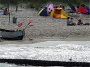 Ostseebad Koserow auf Usedom: Fischerboot und Badegste auf dem breiten Sandstrand.