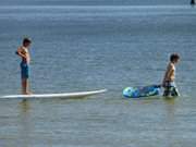 Ohne Segel: Jungen mit Surfbrett am Usedomer Ostseestrand.