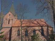 Kurzer Sonnenschein vor dunklem Himmel: Kirche in Stolpe.