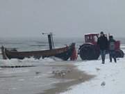 Ostseestrand von Klpinsee: Ein Fischerboot wird angelandet.