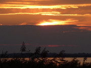 Das Achterwasser bei Loddin: Sonnenuntergang hinter Wolken.