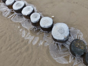 Winter an der Ostseekste: Eisornamente an den Buhnen.