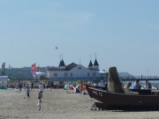 Weier Strand, Fischerboot und blaues Meer.