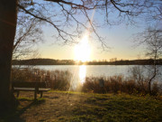 Am Klpinsee: Bank im letzten Sonnenlicht des Tages.