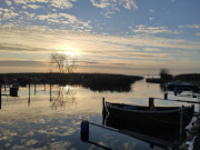 Einsames Fischerboot: Wolken spiegeln sich im Loddiner Hafen.