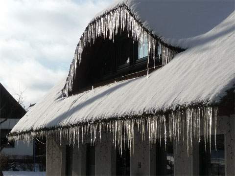 Eiszapfen als Zierelement: Reetdachhaus im Bernsteinbad Loddin.